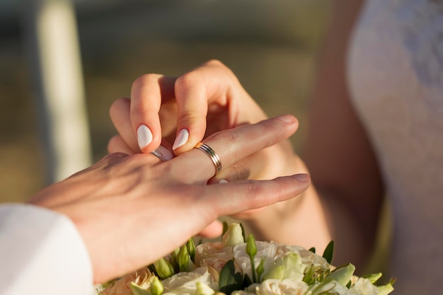 Les mains de la mariée mettent une bague au marié Jour du mariage