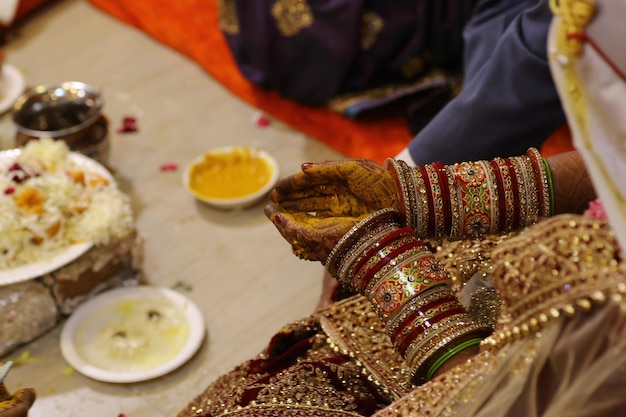 Photo les mains d'une mariée sont remplies de nourriture de couleur jaune et rouge.