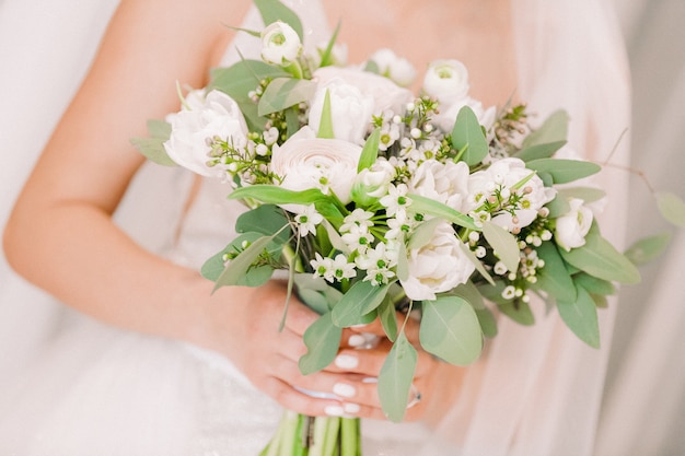 Les mains de la mariée tiennent beau bouquet de mariée