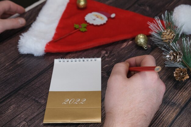 Les mains masculines en gros plan un homme écrit une lettre au concept du père noël pour le nouvel an de noël