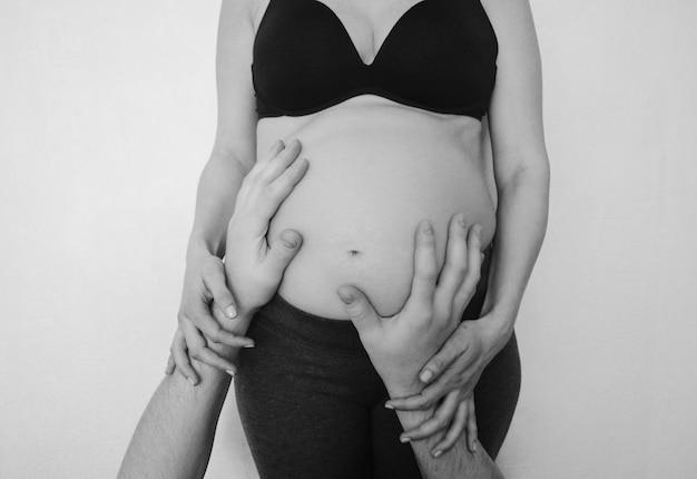 Mains masculines sur le ventre d'une femme enceinte grossesse familiale Concept