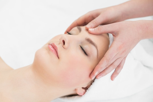 Mains massant un front de belle femme