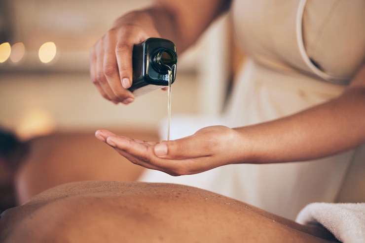 Photo mains de masseuse et huile pour le massage du dos relaxant ou lubrifiant dans le salon ou le spa du complexe