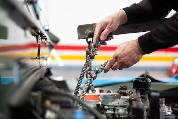 Mains d'un mécanicien réparant une voiture Personne méconnaissable travaillant dans un atelier