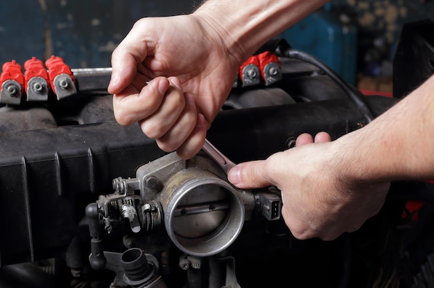 Mains de mécanicien de réparation de moteur de service de voiture avec clé