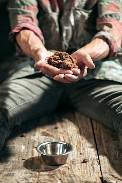 Mains de mendiant masculin cherchant de la nourriture ou de l'argent avec des pièces d'étain de la bonté humaine