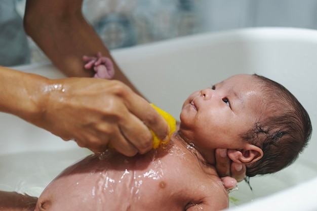 Photo mains de mère tenant de petites filles en bas âge dans une salle de bains