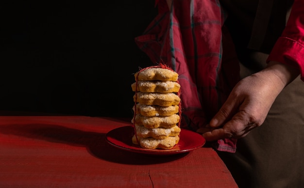 Mains montre des biscuits sur une table en bois rouge sur le noir