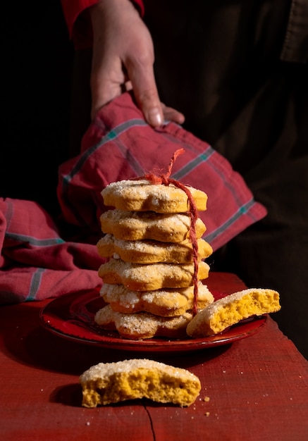 Mains montre des biscuits sur une table en bois rouge sur le noir