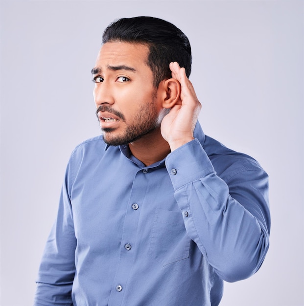 Mains oreille et portrait d'un homme frustré en studio pour les commérages écouter ou parler signe sur fond gris Palm secret et visage d'un type japonais avec une icône emoji pour le langage des signes sourds ou quoi
