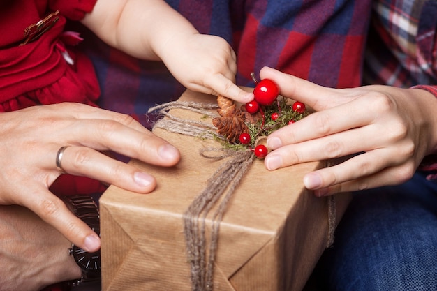 Mains de parent et enfant tenant une boîte-cadeau de Noël. Bonne année