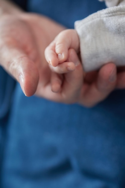 Mains de parents asiatiques tenant les doigts de bébé nouveau-né Gros plan la main de la mère tenant leur bébé nouveau-né