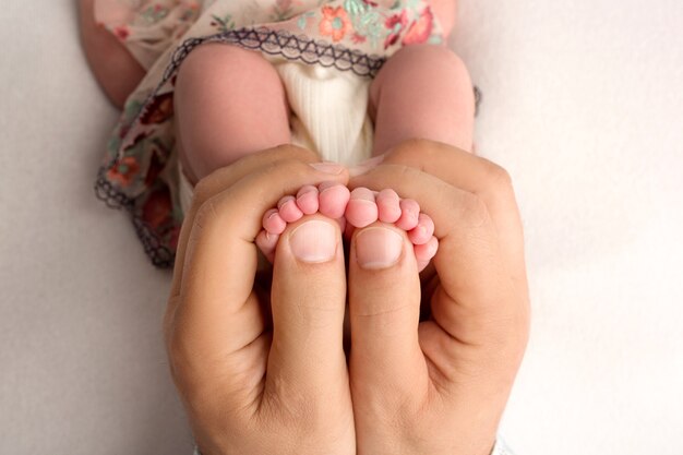 Mains des parents. Les jambes, les pieds du nouveau-né entre les mains de maman et papa. photo de haute qualité