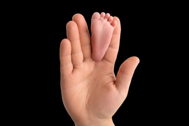 Mains des parents. Les jambes, les pieds du nouveau-né entre les mains de maman et papa. photo de haute qualité