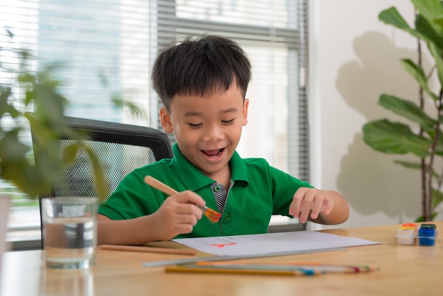 Mains de peinture petit garçon et table pour la créativité