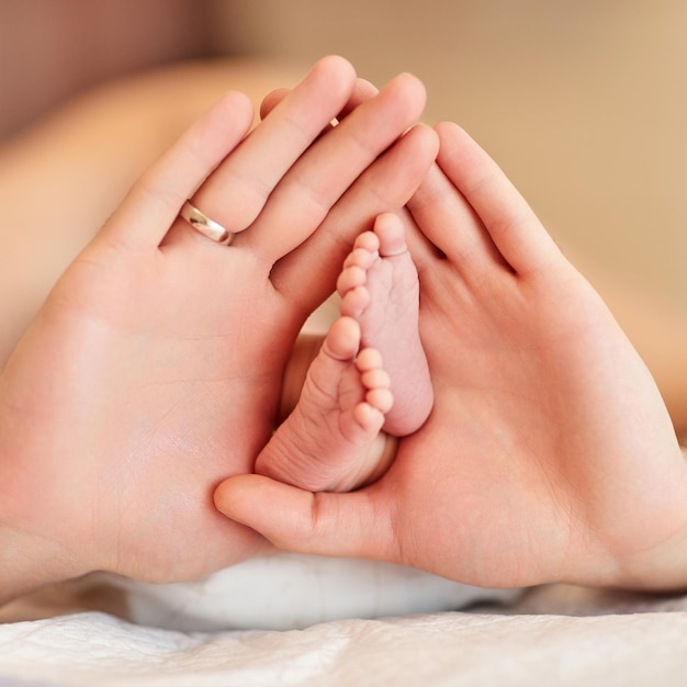 Mains de père tenant des pieds de bébé nouveau-né
