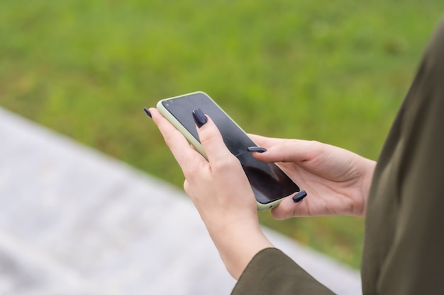 Mains d'une personne méconnaissable avec un téléphone portable à disposition