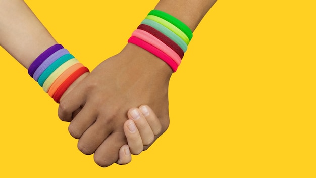 Les mains de personnes de différentes nationalités se tenant sont le symbole arc-en-ciel, le thème lgbt, la fierté, arrêtez la haine asiatique, copiez l'espace