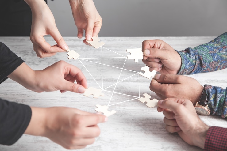 Mains de personnes tenant un puzzle. Connexion, partenariat, succès, travail d'équipe