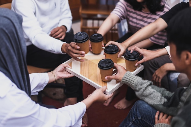 Mains de personnes tenant des tasses de café