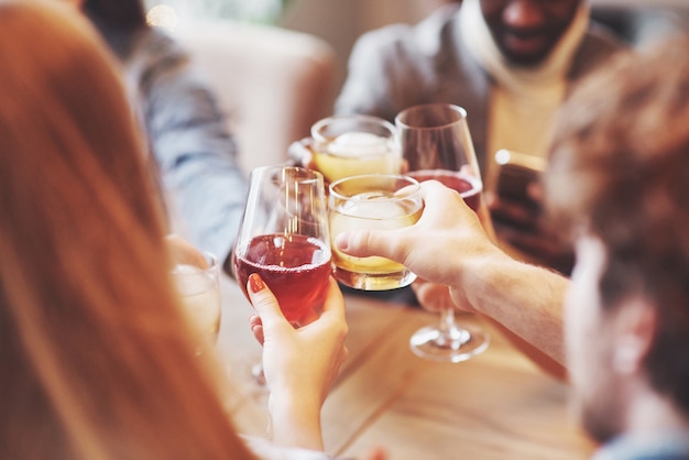 Mains de personnes avec des verres de whisky ou de vin, célébrer et griller