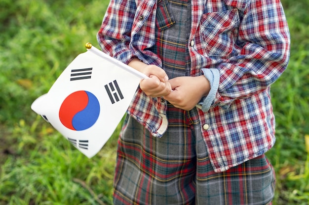 Photo mains de petit garçon tenir le drapeau