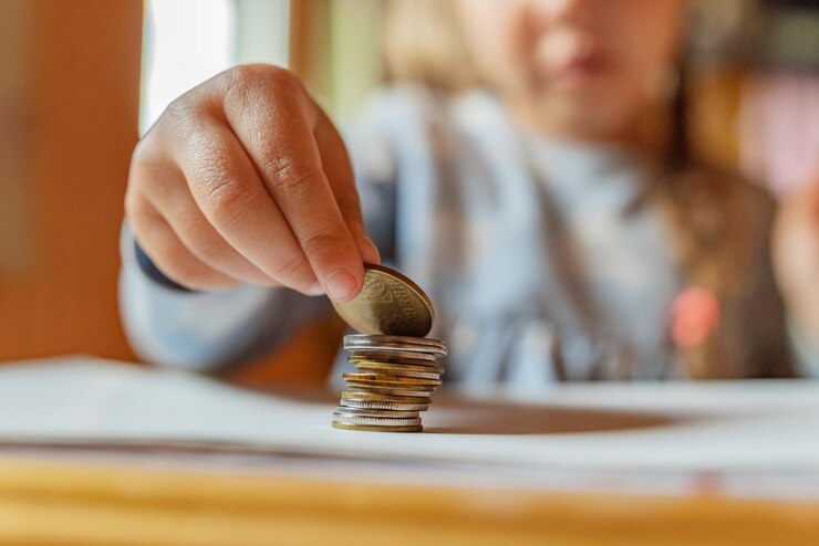 Photo les mains d'une petite fille jouent avec des pièces de monnaie et de l'argent premières leçons de finance accumulation crédit enfant économisant de l'argent pour le futur concept