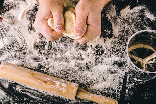 Mains pétrissant une pâte