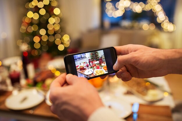 Des mains photographiant de la nourriture au dîner de Noël
