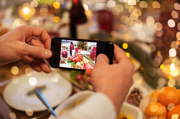Des mains photographiant de la nourriture au dîner de Noël
