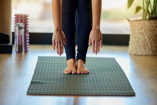 Mains pieds et yoga avec une femme dans sa maison pour une séance d'entraînement de santé mentale ou de bien-être Exercice de pilates ou d'étirements et une formation de yogi féminine avec une flexion vers l'avant seule pour le zen