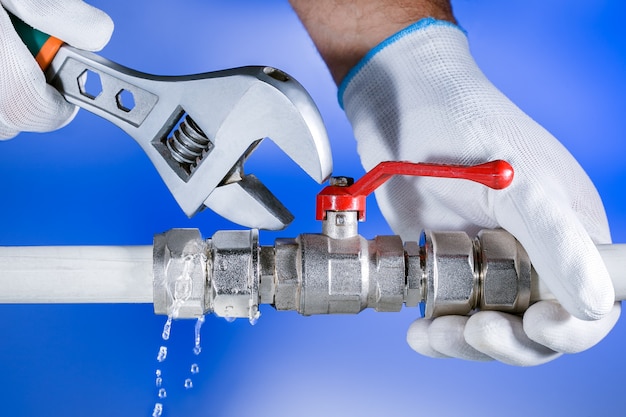 debouchage gembloux mains plombier au travail dans une salle de bain, service de réparation de plomberie. fuite d'eau. réparer la plomberie.