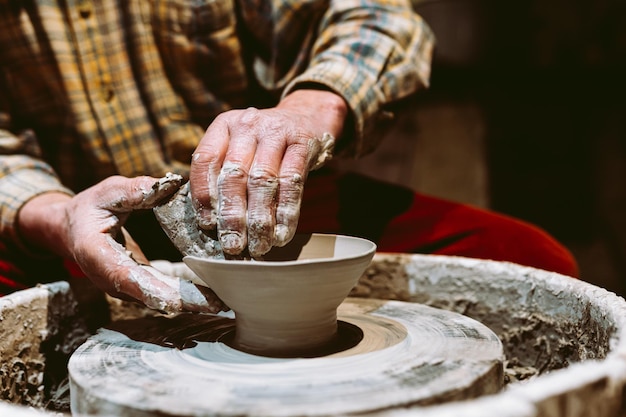 Mains potier créant un pot en terre