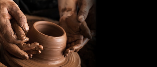 Mains de potier faisant un pot en argile, photo gros plan