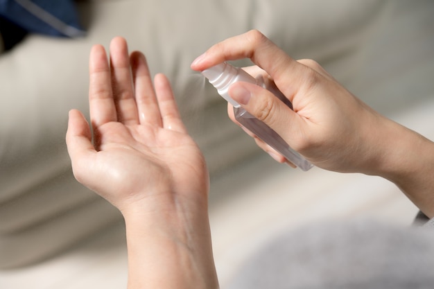 Mains pulvérisant un désinfectant à l'alcool pour l'hygiène et la protection de la désinfection.