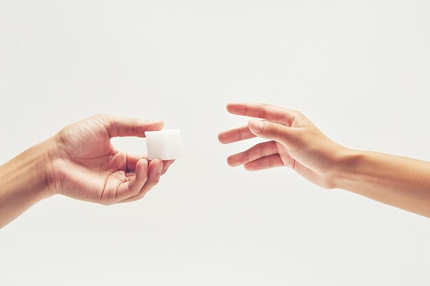 Les mains qui passent un cube de sucre conceptuellement