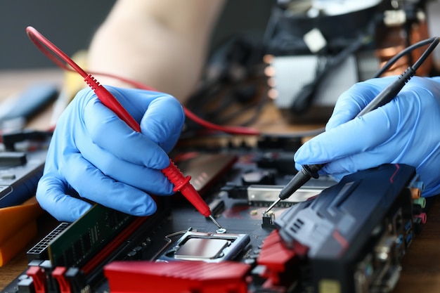 Les mains réparent un appareil électronique, soudent