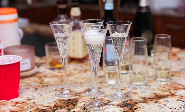 Les mains saisissent les verres pour porter un toast à la connexion de la célébration et à l'indulgence de la représentation de l'alcool et du champagne