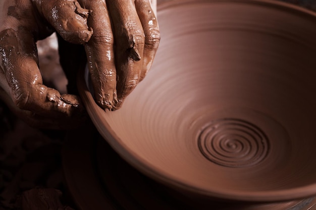 Mains sales dans l'argile et le tour de potier avec le produit Creation Working potter