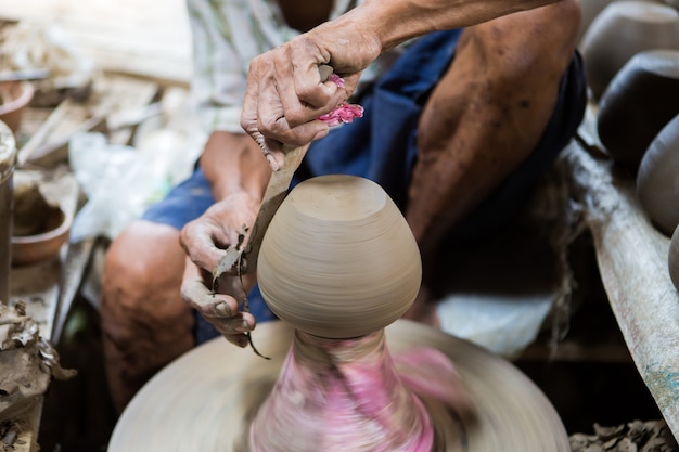 mains sales faisant de la poterie dans l&#39;argile sur la roue