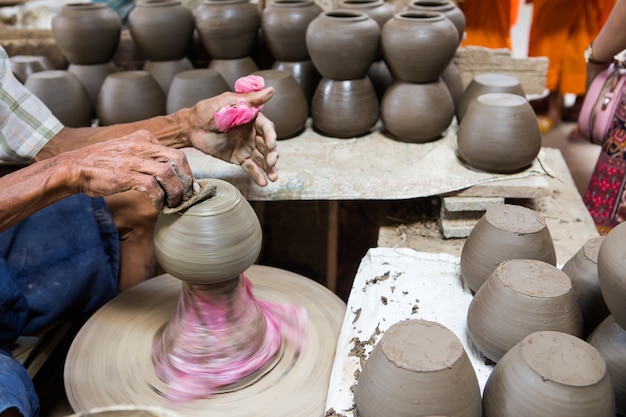 mains sales faisant de la poterie dans l&#39;argile sur la roue