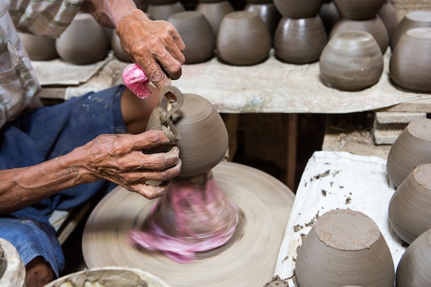 mains sales faisant de la poterie dans l&#39;argile sur la roue