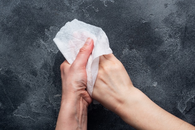 Les mains sont essuyées avec un chiffon antibactérien humide sur le béton