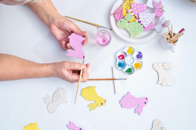 Mains supérieures préparant la décoration de pâques pour peindre des lapins