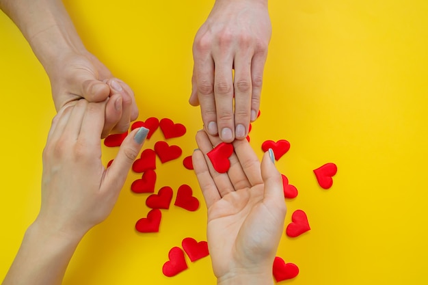 Les mains sur une surface jaune avec des coeurs