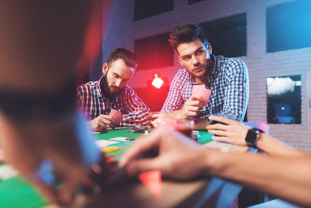 Les mains sur la table montrent des cartes dans la salle de jeux.