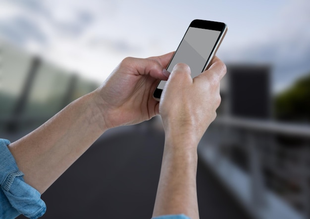 Mains avec téléphone contre pont flou