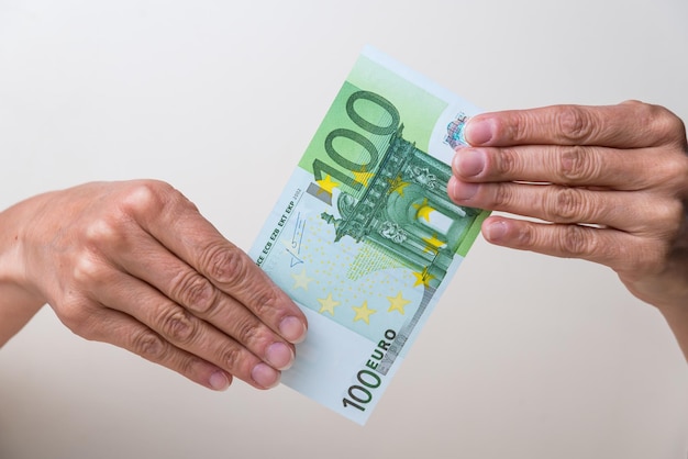 mains tenant un billet de cent euros