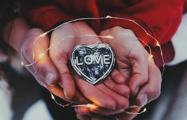 Mains tenant le coeur de pierre avec texte d'amour.