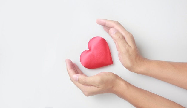 Mains tenant un coeur rouge. concepts de don de santé cardiaque